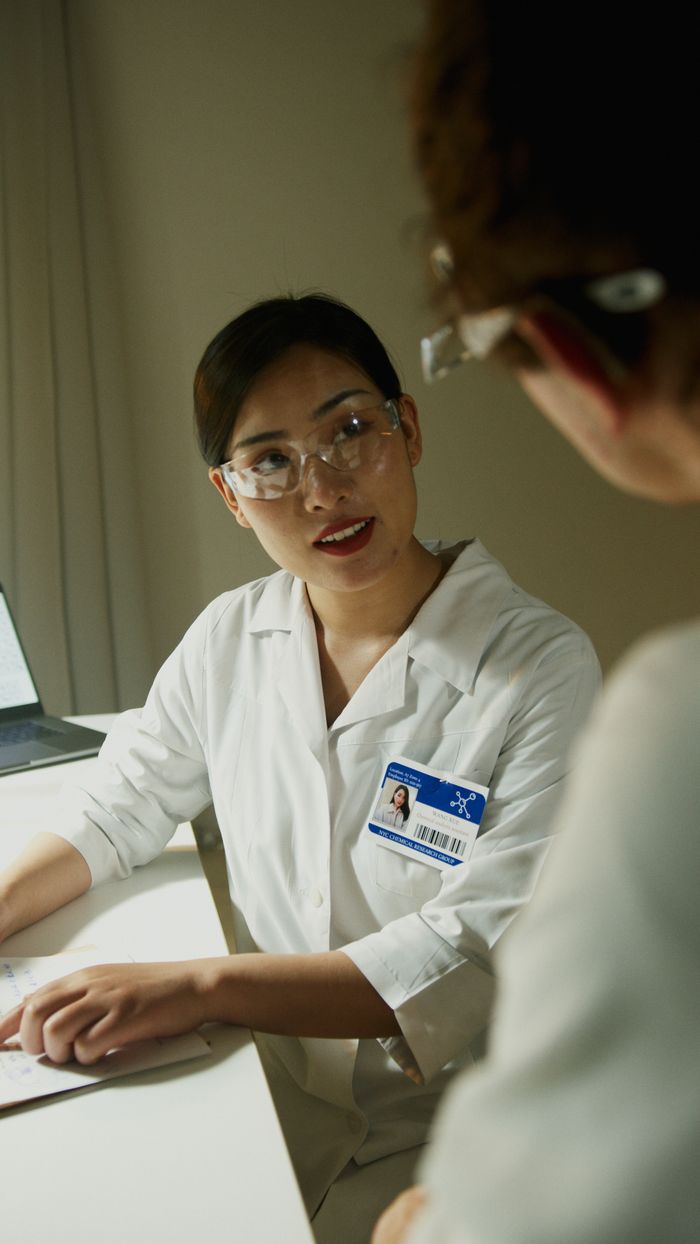 About A female scientist wearing a lab coat and goggles in a laboratory environment.